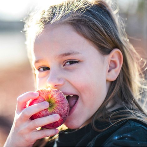 Happy girl eating apples